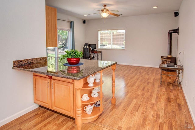 kitchen featuring a peninsula, light wood-style flooring, light brown cabinetry, and ceiling fan