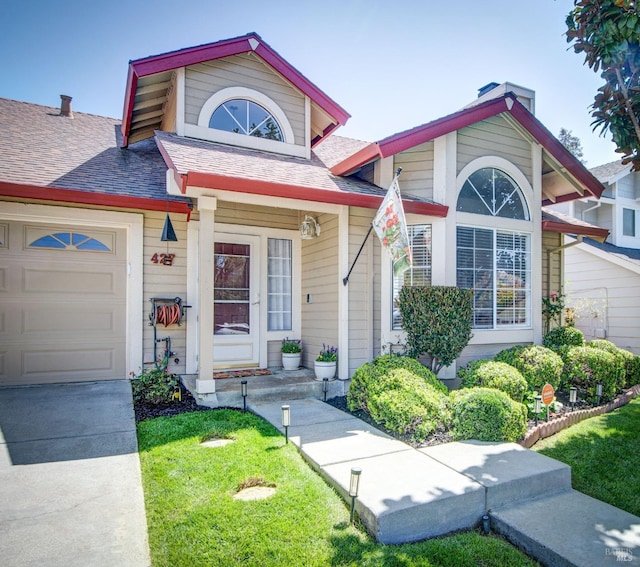 view of front of home featuring an attached garage and a front yard