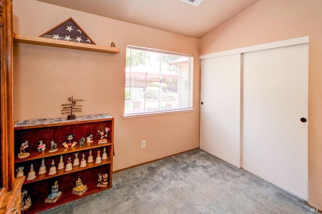 bedroom with lofted ceiling, a closet, visible vents, and carpet