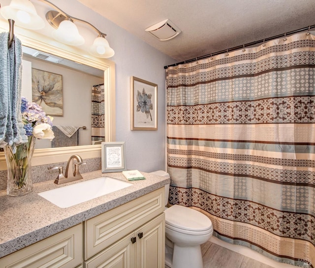 full bath with visible vents, wood finished floors, vanity, and toilet