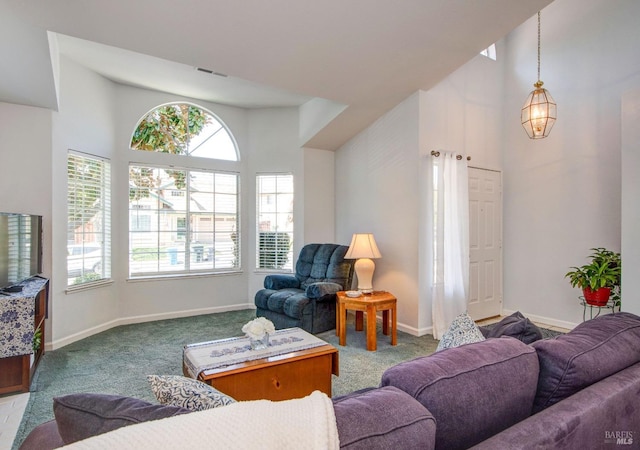 carpeted living room featuring visible vents, a towering ceiling, and baseboards