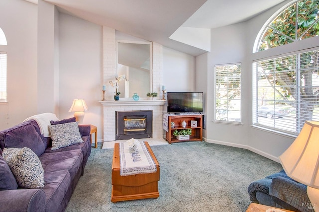 carpeted living area with a fireplace, baseboards, and high vaulted ceiling