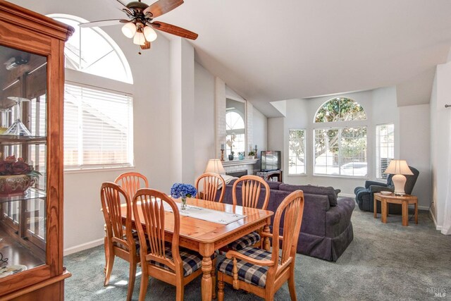carpeted dining space featuring lofted ceiling, a ceiling fan, and baseboards