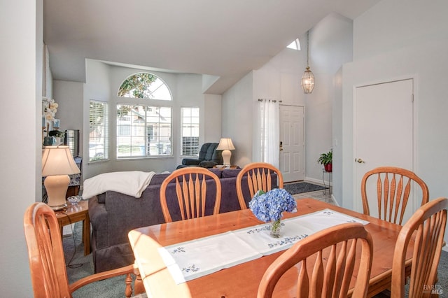 dining space with high vaulted ceiling