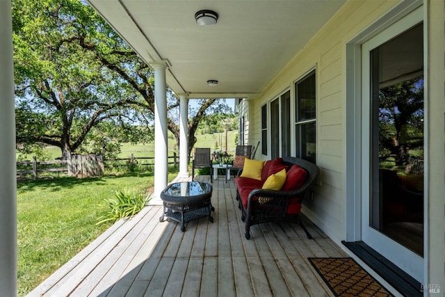 wooden deck featuring a lawn, a fenced backyard, and an outdoor living space