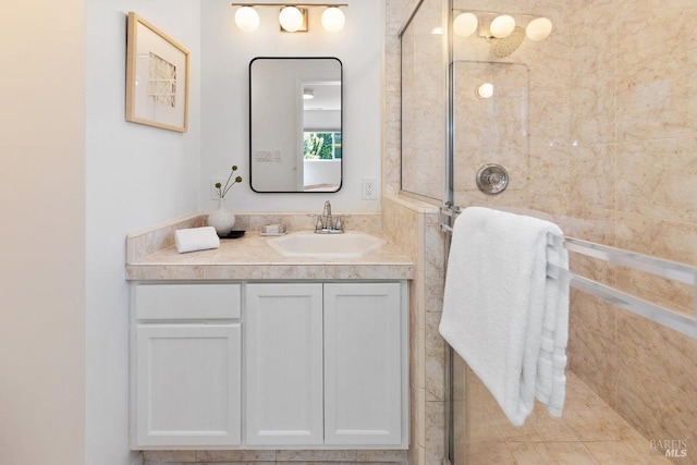 bathroom featuring a tile shower and vanity