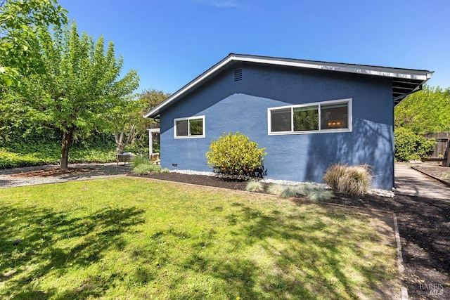 view of home's exterior featuring a lawn and stucco siding