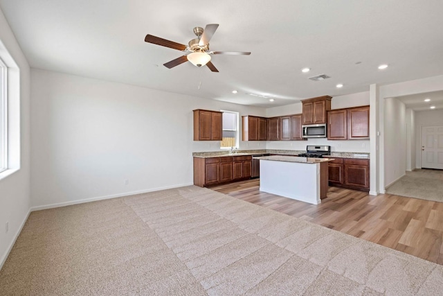 kitchen with recessed lighting, appliances with stainless steel finishes, baseboards, and light carpet