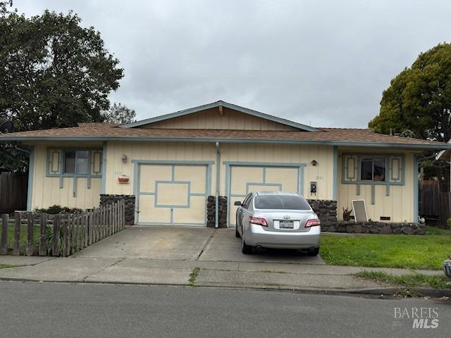 single story home with driveway, fence, and a garage