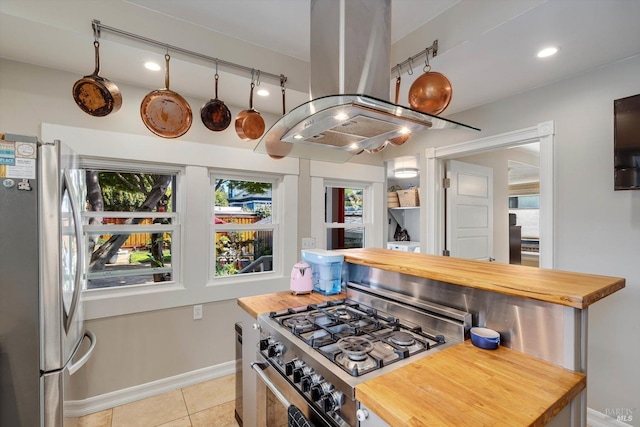 1416 F St, Napa, CA 94559 - kitchen with appliances with stainless steel finishes, butcher block countertops, island exhaust hood, light tile patterned floors, and recessed lighting
