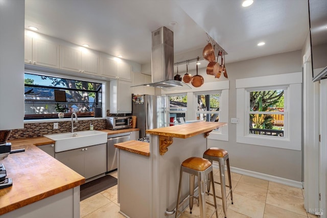 1416 F St, Napa, CA 94559 - kitchen with butcher block countertops, island range hood, appliances with stainless steel finishes, backsplash, and plenty of natural light