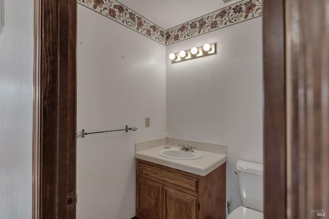 half bathroom with toilet and vanity