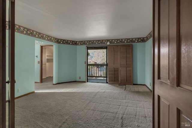 empty room featuring baseboards and carpet