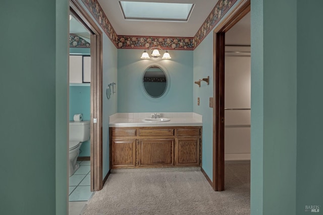 bathroom with toilet, vanity, and baseboards