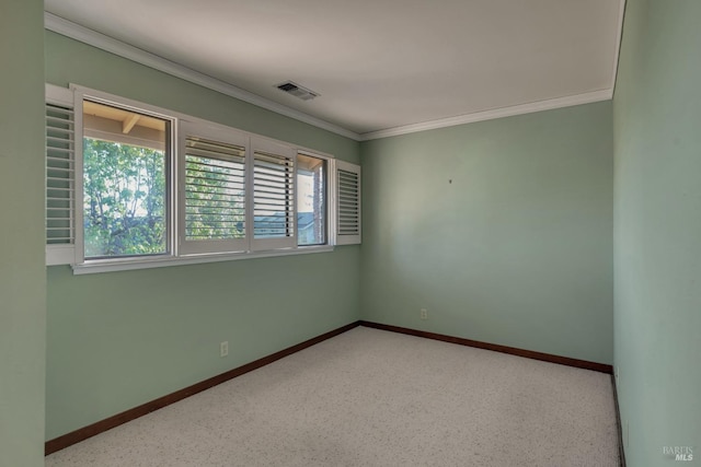 spare room with a wealth of natural light, crown molding, visible vents, and baseboards