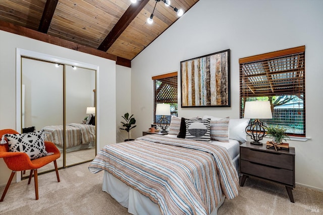 bedroom featuring beamed ceiling, light carpet, wooden ceiling, and a closet