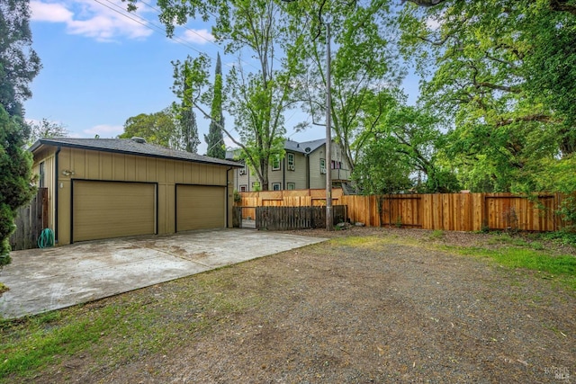 view of yard featuring fence, an outbuilding, and a garage