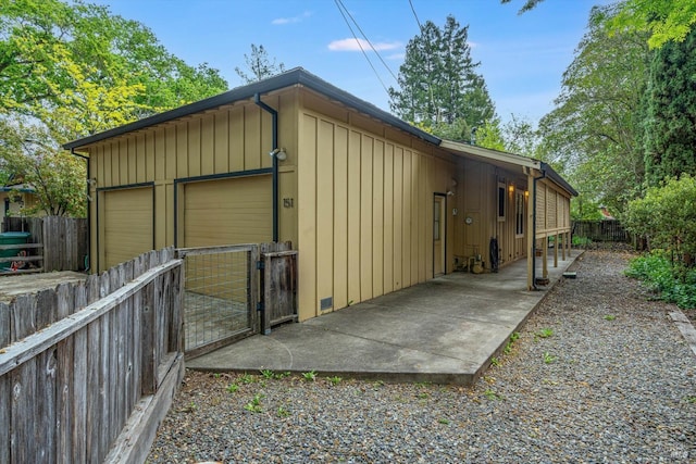 detached garage with a gate and fence