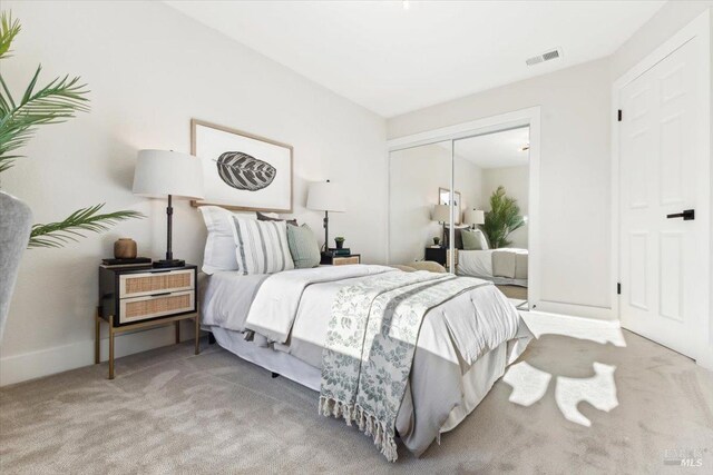 bedroom with baseboards, a closet, visible vents, and carpet
