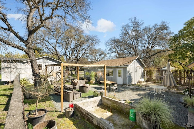 rear view of house featuring fence and an outbuilding