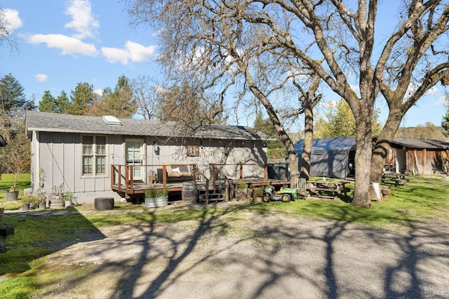 back of property featuring board and batten siding and a deck