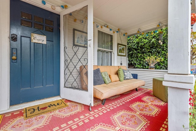 view of exterior entry featuring covered porch