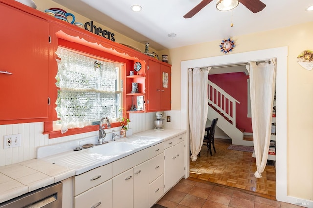kitchen with a sink, recessed lighting, ceiling fan, open shelves, and dishwasher