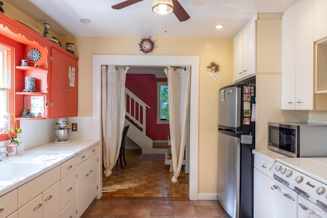 kitchen with open shelves, ceiling fan, light countertops, and appliances with stainless steel finishes