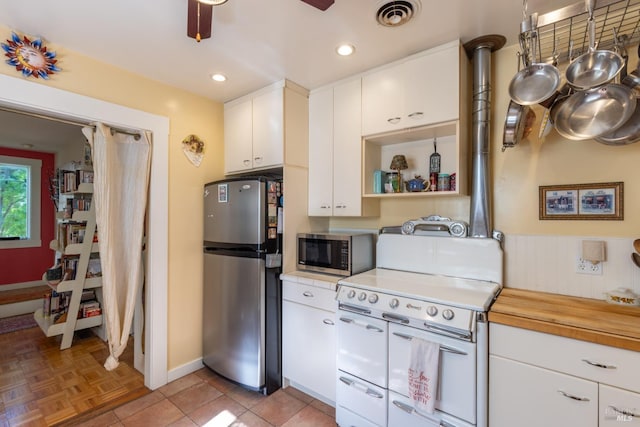 kitchen featuring visible vents, white cabinetry, baseboards, appliances with stainless steel finishes, and ceiling fan