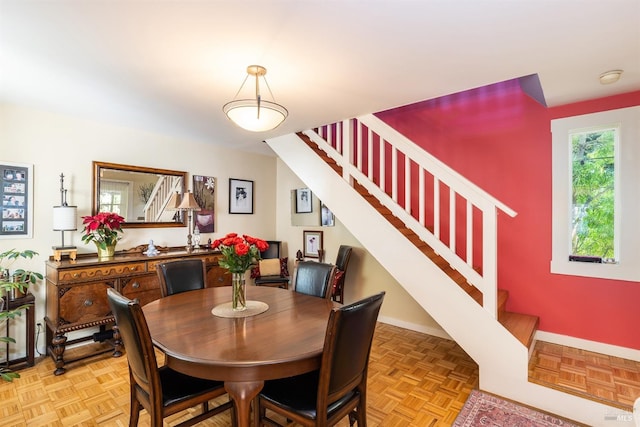 dining area with baseboards and stairs