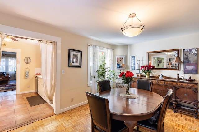 dining space with baseboards and ceiling fan