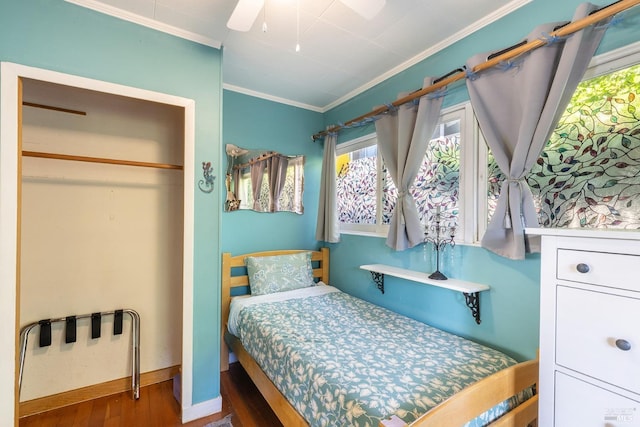 bedroom with wood finished floors, ornamental molding, and multiple windows