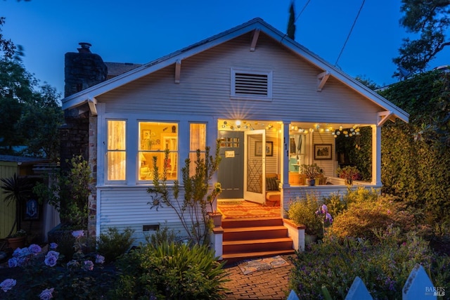 rear view of property with a porch and a chimney