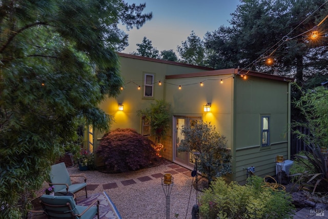 view of front of house featuring stucco siding and a patio area