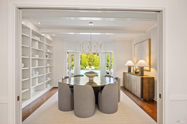 dining area with ornamental molding, a chandelier, and wood finished floors