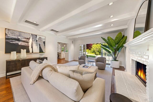 living area featuring a fireplace, beam ceiling, baseboards, and visible vents