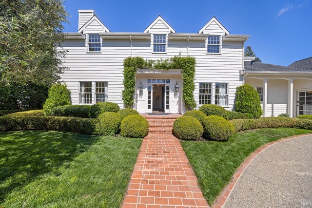 view of front of property featuring a front lawn and a chimney