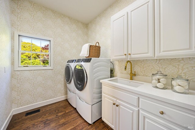 laundry area featuring visible vents, a sink, dark wood-type flooring, separate washer and dryer, and cabinet space