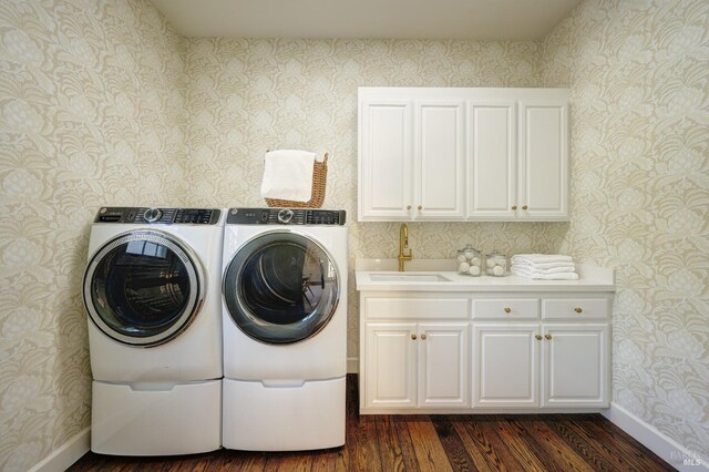 laundry room featuring a sink, separate washer and dryer, wallpapered walls, cabinet space, and dark wood-type flooring