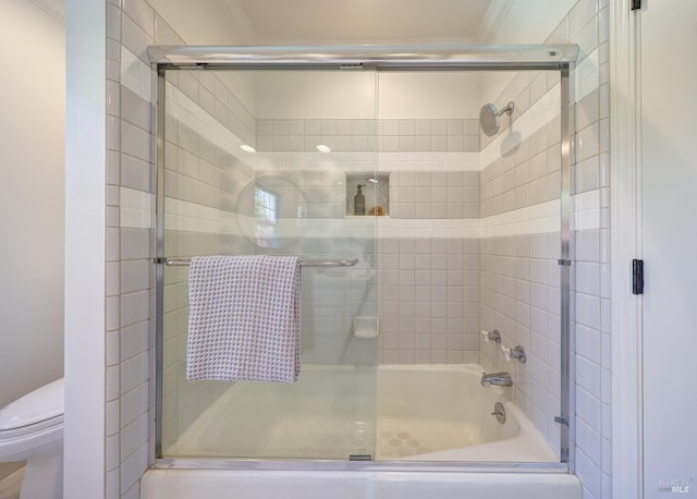 bathroom with crown molding, combined bath / shower with glass door, and toilet