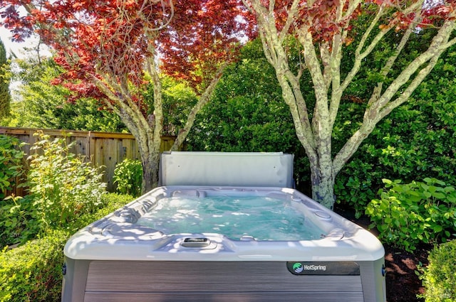 deck featuring fence and a hot tub