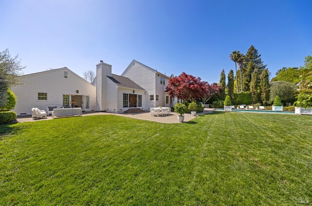 rear view of house with a jacuzzi, a patio area, outdoor lounge area, an outdoor pool, and a yard