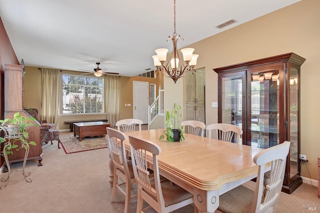 dining room with light colored carpet, baseboards, visible vents, and ceiling fan with notable chandelier