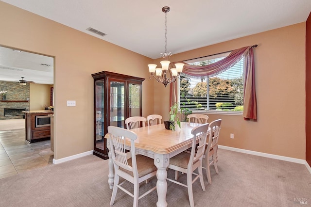 dining space with an inviting chandelier, light carpet, visible vents, and baseboards
