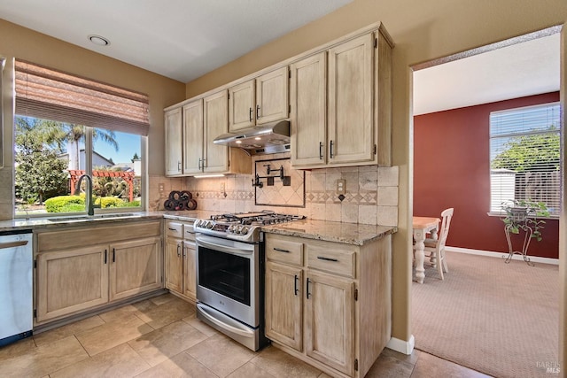 kitchen featuring under cabinet range hood, light brown cabinetry, and stainless steel appliances