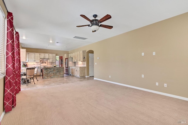 living area featuring ceiling fan, arched walkways, light carpet, baseboards, and visible vents