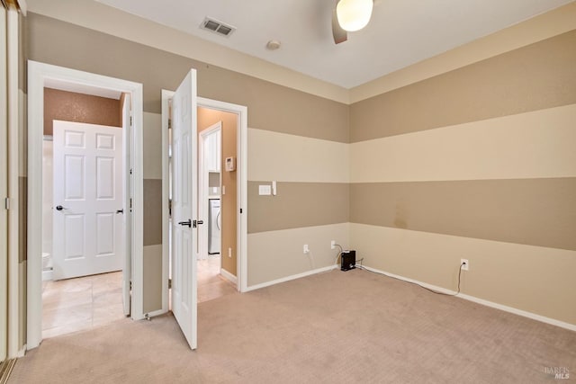 laundry area featuring light carpet, baseboards, visible vents, laundry area, and washer / dryer