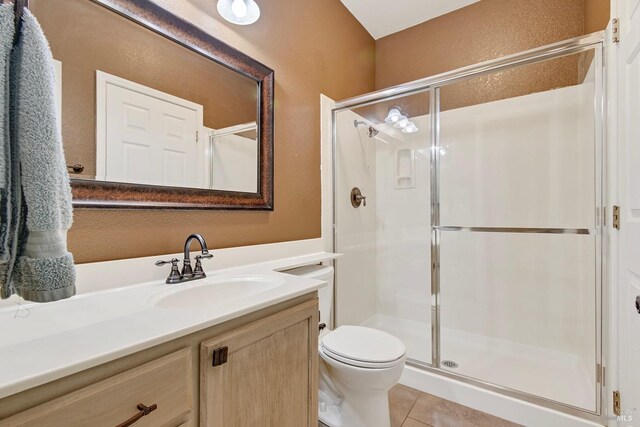 bathroom featuring vanity, tile patterned flooring, a shower stall, and toilet