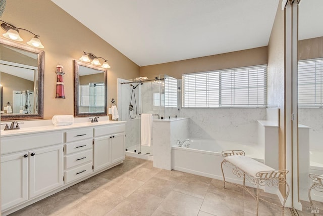 full bath with a garden tub, a sink, double vanity, and a stall shower