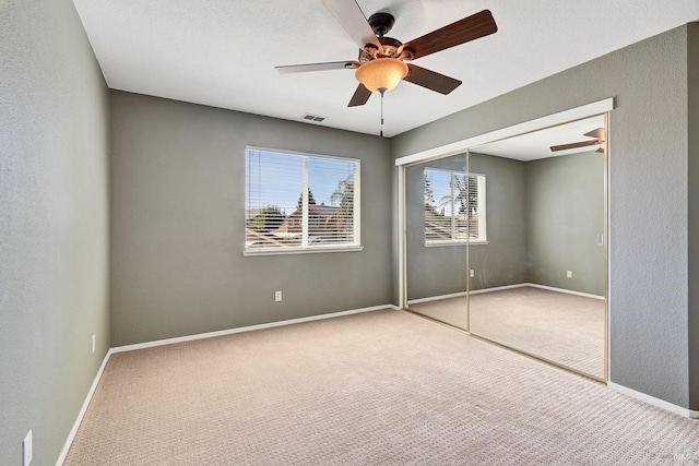 unfurnished bedroom featuring visible vents, carpet floors, and multiple windows